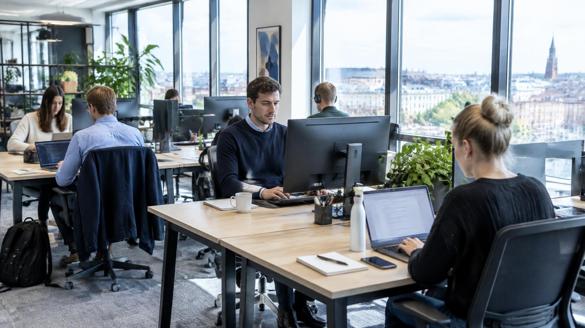Modern open-plan office interior with people working at desks